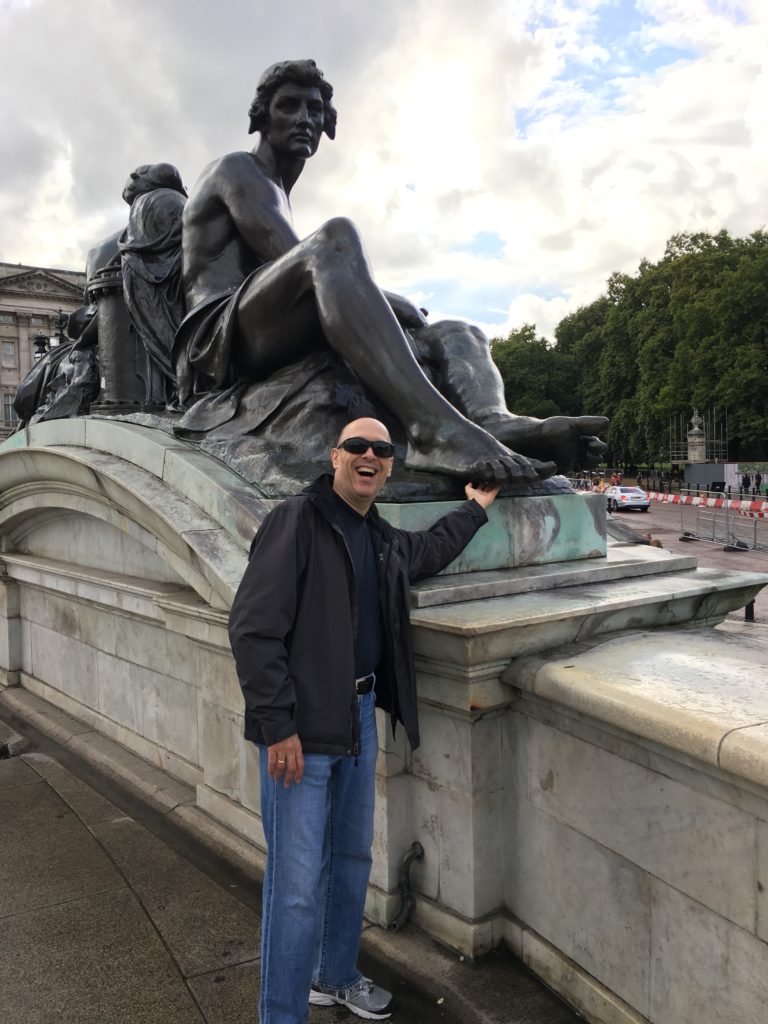 I'm standing in front of a statue with its barefoot up on an angle. It looks like I am tickling the foot.