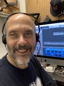 David is pictured wearing his Sennheiser Headset with Garageband showing on the iMac behind him.