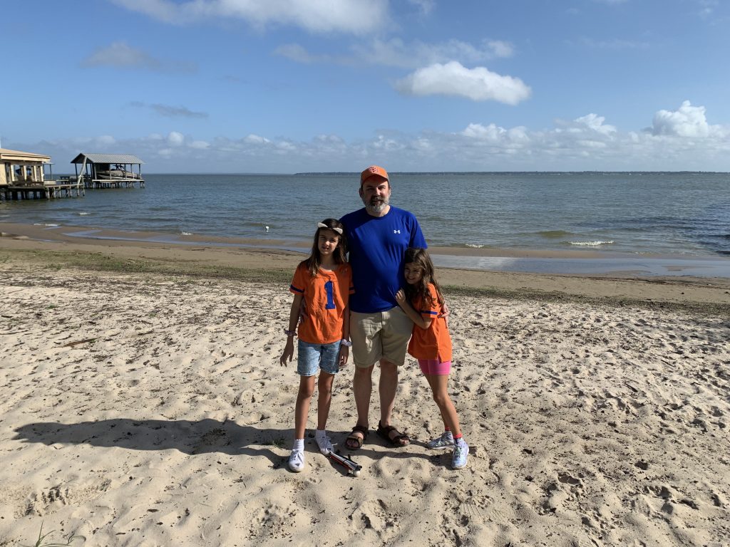 David Cleveland and his daughters on a beach.