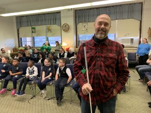 I'm pictured in front of the kids at St. Lucy Day School. They are distracted, because they are listening for their names to be called by Santa to go and get their gift which was provided by the Keystone Chapter of the National Federation of the Blind of PA.